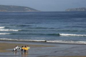 Conocer Galicia es más fácil ahora con Yakart Centro Caravaning. Surfistas en la playo do Razo